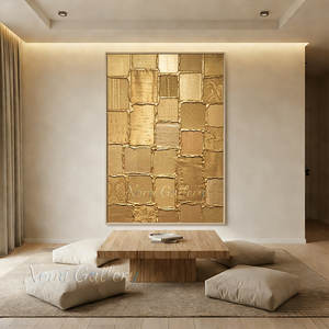 Large handmade 3D abstract canvas painting showcasing elegant fluid metallic gold lines curving across a heavy white plaster textured background, framed in black and styled on a warm minimalist living room wall above a beige sofa.