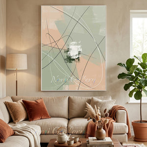 Large handmade abstract canvas painting with layered color blocks of sage green, olive, and warm cream overlapped with fine black and white curved lines, framed in black and mounted on a minimalist wall in a modern living room interior.