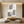 A hand-painted minimalist oil painting featuring overlapping beige and taupe geometric squares with thin black intersecting circular arcs, styled in a warm modern living room.