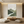 Hand-painted abstract oil painting with heavy 3D textures in various shades of green, including emerald and sage, resembling a forest floor, styled in a modern living room with natural wood furniture.