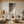 Hand-painted 3D textured abstract wall art featuring undulating waves in terracotta and beige, styled in a modern Boho living room above a beige sofa.
