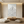 A hand-painted 3D textured oil painting in all-white, showing sculpted mountain peaks with heavy impasto ridges, styled in a minimalist Zen-inspired living room.